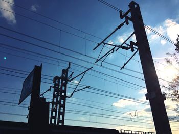 Low angle view of silhouette electricity pylon against sky