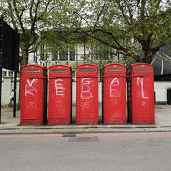 Red garbage bin on street in city