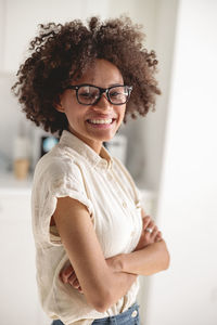 Portrait of young woman standing against wall