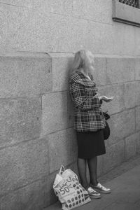 Rear view of woman standing against wall