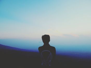 Rear view of man standing against sky