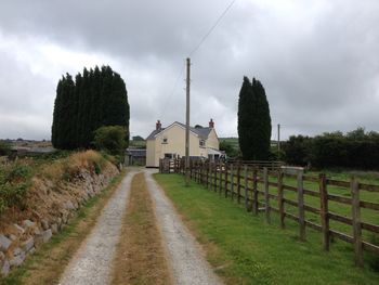 View of field against cloudy sky