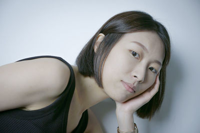 Close-up of young woman against white background