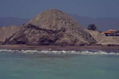 Scenic view of sea and mountains against clear sky