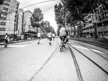 People riding bicycle on street in city