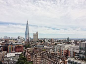 View of cityscape against cloudy sky