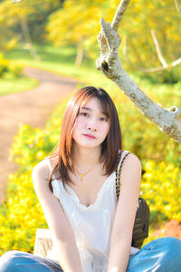 Portrait of young woman sitting on field