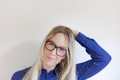 Portrait of young woman against wall