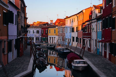 Canal amidst buildings in city against sky