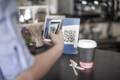 Hand holding smart phone, scanning barcode