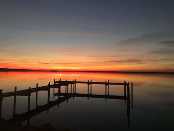 Pier over sea against sky during sunset