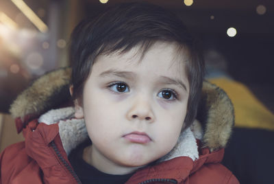 Close-up of cute boy looking away at home