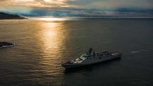 Boats in sea against sky during sunset