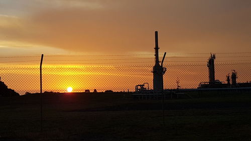 Silhouette field against sky during sunset