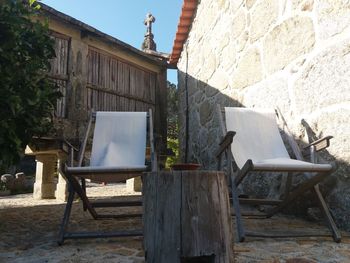 Tables and chairs against wall of house