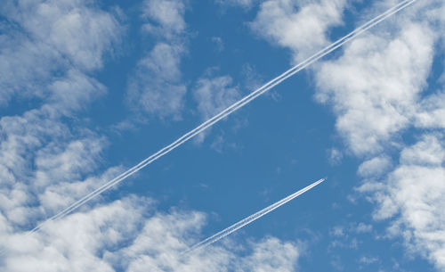 Low angle view of vapor trail against blue sky