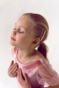 Gymnast girl in pink velvet bodysuit stands in studio background white