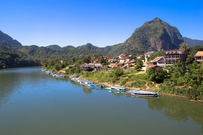 Scenic view of lake by mountains against clear sky