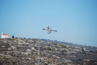 Airplane flying against clear blue sky