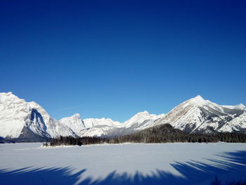 Scenic view of snowcapped mountains against clear blue sky