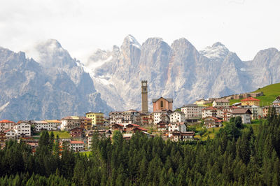 Panoramic shot of townscape by mountains against sky