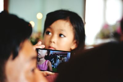 Close-up of child holding mobile phone at home