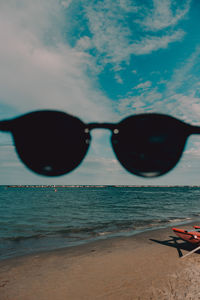 Close-up of sunglasses on beach