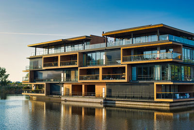 Building by river against sky