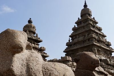 Low angle view of statues against building against sky