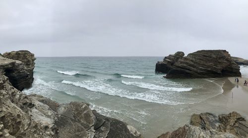 Scenic view of rocks in sea against sky