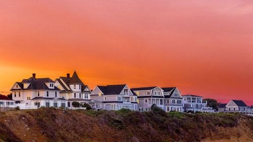 Buildings in town against sky during sunset