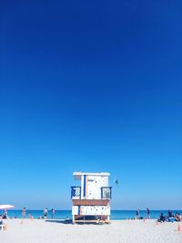 Scenic view of beach against clear blue sky