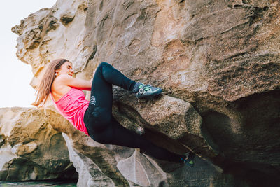 Woman climbing on rock formation