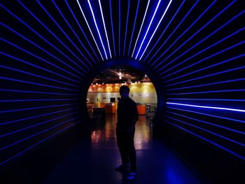 Rear view of man walking in city at night