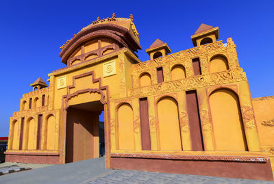 Low angle view of historical building against clear blue sky