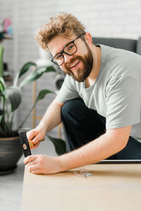 Young man using mobile phone while sitting on table