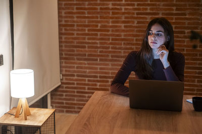 Young woman using laptop while sitting at home