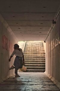 Rear view of woman walking on steps