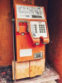 Close-up of old telephone booth on wall