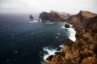 Rock formations on sea against sky