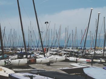 Sailboats moored at harbor