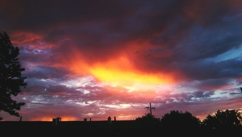 Silhouette of trees against cloudy sky