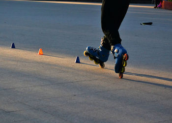 Rear view of person roller skating on road