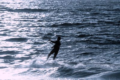 Silhouette man surfing in sea