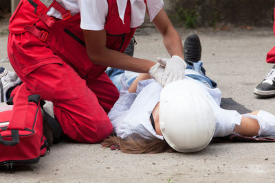 Midsection of paramedic performing cpr on mannequin