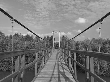 Footbridge over footpath against sky