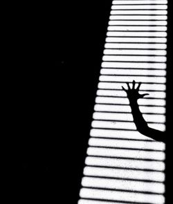 Close-up of silhouette person shadow on hand