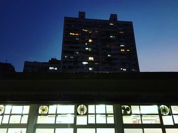 Low angle view of illuminated skyscraper against sky at night