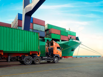 The container vessel during discharging at industrial port and move containers to container ysrd.