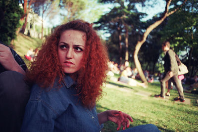 Mid adult woman looking away while sitting in park